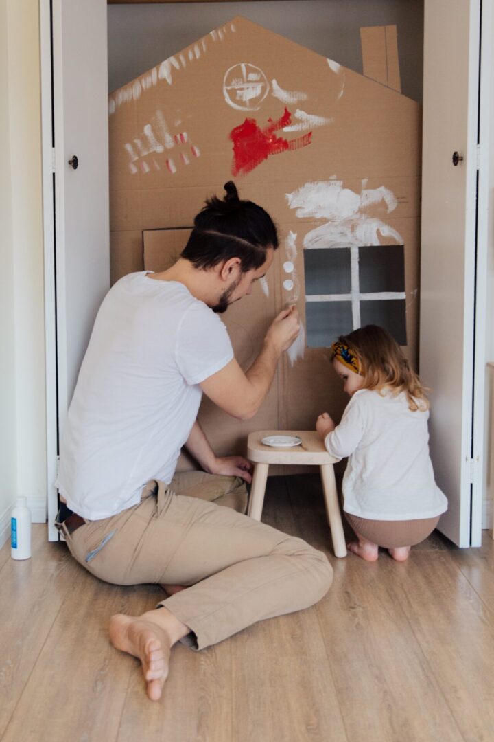 man-in-white-t-shirt-and-brown-pants-painting-cardboard-3933227